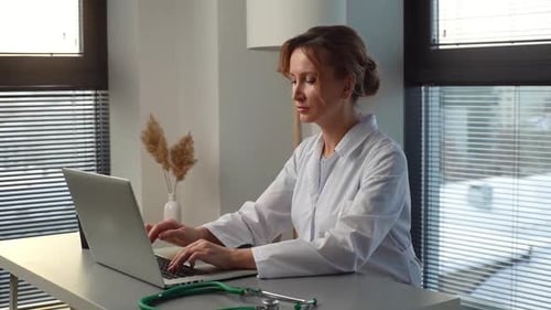 Woman Doctor Working on Laptop in Office