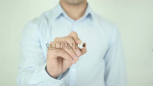 Man Writing Reliability with Marker on Clear Surface