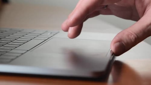 Hand Interacting with Laptop Trackpad at Work
