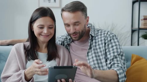 Couple Relaxing Using a Tablet on Sofa