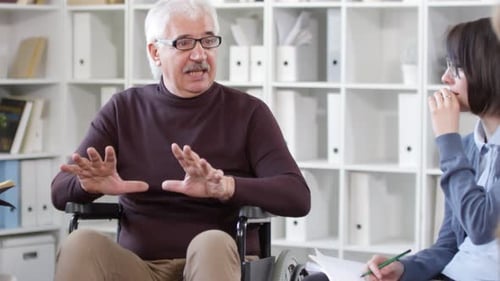 People Discussing in Office with Man in Wheelchair