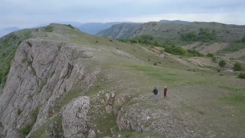 Flyover Hiking Couple Enjoying Beautiful View in the Mountains. Aerial Two People Couple Holding
