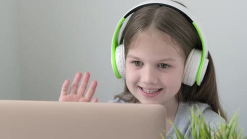 School Girl Pupil During Video Call Online Via Internet on Laptop with Headphones