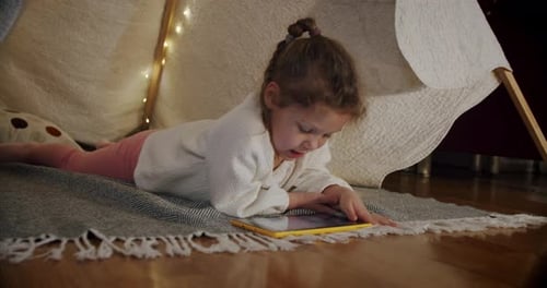 Girl Using Tablet in Play Tent at Home