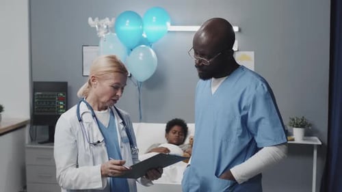 Pediatrician and Nurse Talking in Clinic