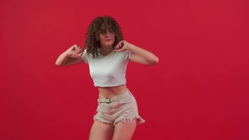 Young Woman Dancing on Red Background