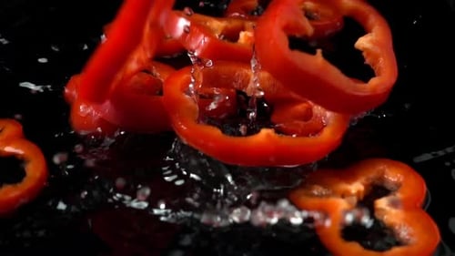 Red Bell Pepper Slices Falling into Water