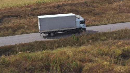 Aerial Shot of Truck with Cargo Trailer Driving on Road and Transporting Goods. Flying Over Delivery
