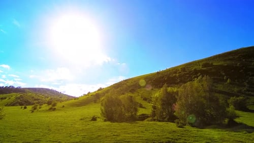 Mountain Meadow Timelapse at the Summer. Clouds, Trees, Green Grass and Sun Rays Movement.