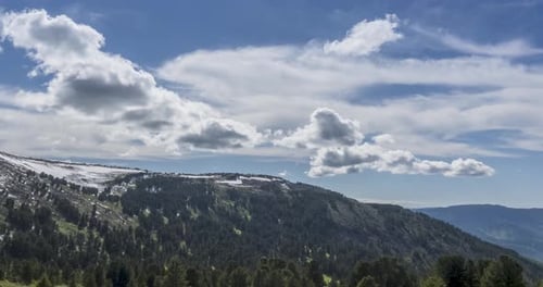Time Lapse of Cloudscape Behind of the Mountains Top. Snow, Rocks, Cliffs and Deep Blue Sky. High