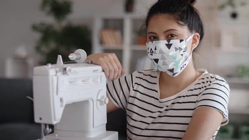 Handheld portrait video of Asian woman with sewing machine