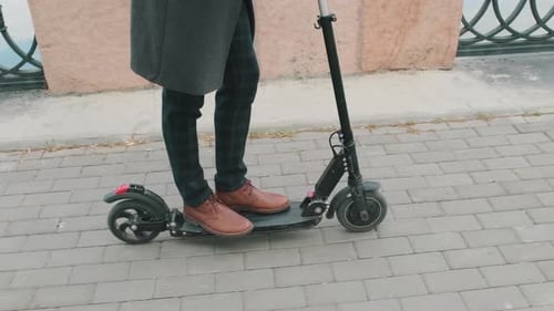 Mann fährt Elektroroller im Freien