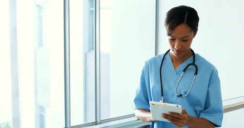 Female doctor using digital tablet in corridor
