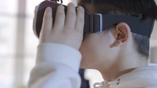 Portrait Of Boy Putting On VR Headset