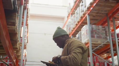 African American Warehouse Worker Doing Inventory with Scanner
