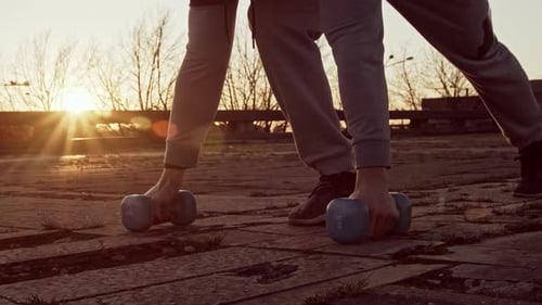 Man Doing Pushups With Weights at Sunset