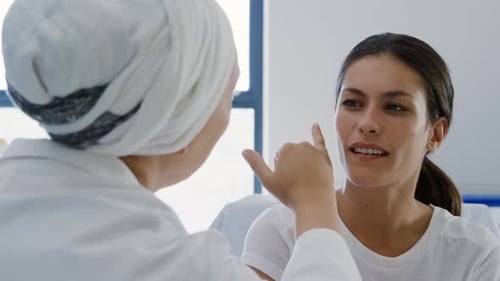 Doctor and Patient Speaking in Hospital Room