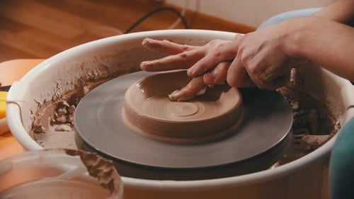 Poterie - Le maître retire l'argile du fond du bol en argile