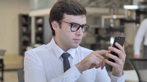 Young Adult Using Smartphone in Office Setting