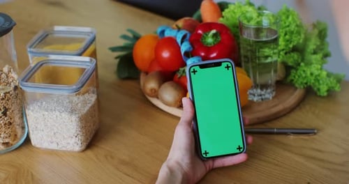 Nutritionist Woman with Healthy Fruit and Vegetable Using Smartphone with Green Screen
