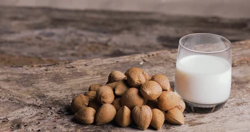 Almond Milk and Whole Almonds on Rustic Wood