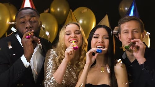 Friends in Birthday Hats With Party Blowers Standing Under Falling Confetti