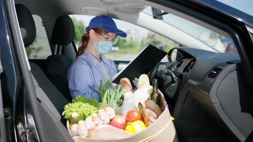 Delivery Driver Reviewing Grocery Order in Car