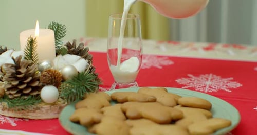 Traditional Christmas Gingerbread Cookies with Ginger on a Wooden Stand. In a Glass Cup, Milk