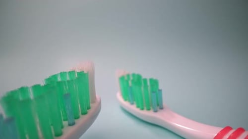 Two Toothbrushes with Worn Bristles Close Up