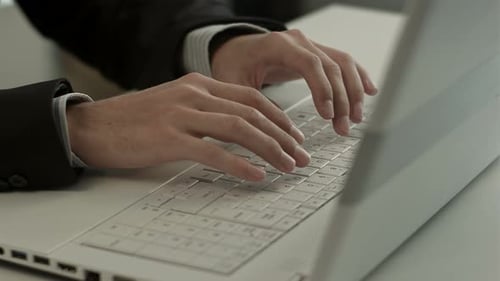 Man typing on a computer keyboard close up