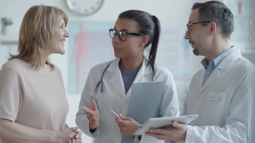 Male and Female Doctors Showing Test Results on Tablet to Woman