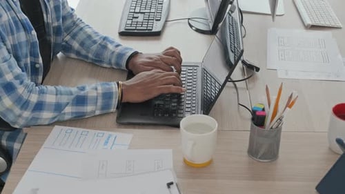 Desarrollador de software escribiendo en una computadora portátil en la oficina