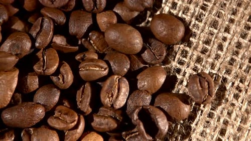 Handful of Brown, Roasted Coffee Beans on Burlap Sacking, Background, Close Up, Rotation