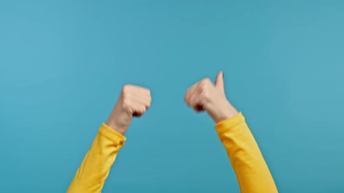 Hands of Woman Showing Thumbs Up Schild auf blauem Hintergrund