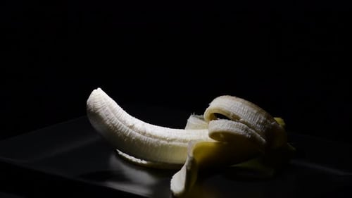 Peeled Banana on a Dark Plate