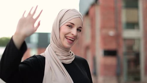 Porträt einer jungen muslimischen Frau mit Hijab-Kopftuch in der Stadt, während sie in die Kamera schaut