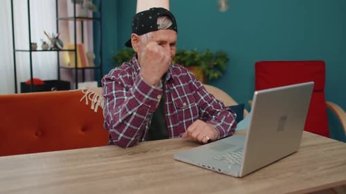 Обрадованный старший дедушка с ноутбуком празднует успех, выигрывает деньги в лотерее онлайн Хорошие новости