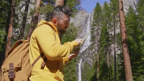Viajante com mochila turística em pé na câmera vermelha panorâmica da natureza de Yosemite