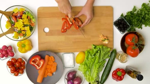 Preparing fresh salad ingredients in kitchen