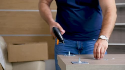 Close Up Man Assembling a Desk Legs in New House