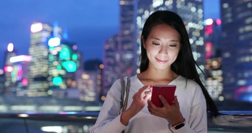 Woman use of mobile phone in city at night