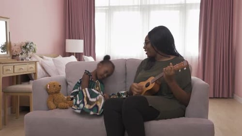 Mother and Daughter Singing and Playing Ukulele