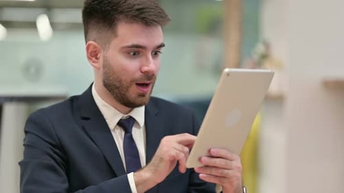 Excited Businessman Celebrating Good News on Tablet