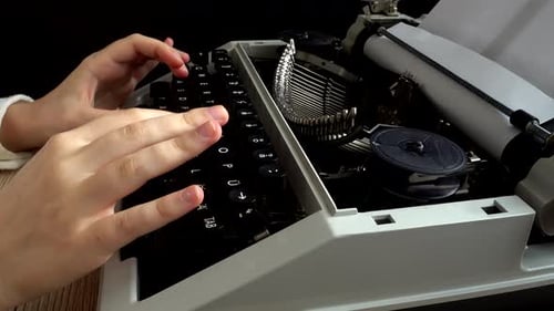 The girl is typing on a retro typewriter.