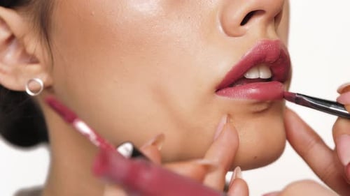 Mode, Make-up, Schönheit, Lippen. Ein schönes Mädchen mit guter Haut schminkt sich für die Lippen