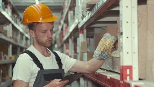 Helmarbeiter überprüft Materialien in der Fabrik