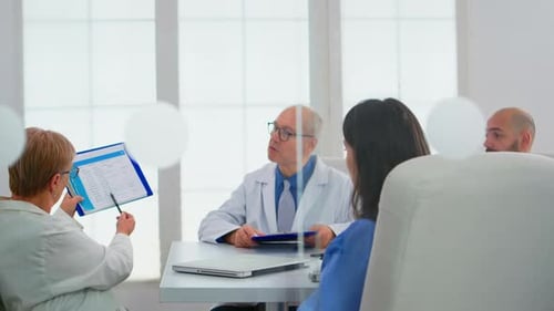Elderly Doctor Having Medical Conference in Hospital Meeting Room