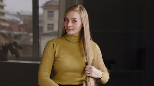 Woman Brushing Her Long Blonde Hair Indoors