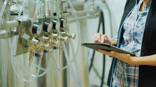 Contrôle de la qualité dans la production. Mains d'un ingénieur avec une tablette sur fond d'instruments