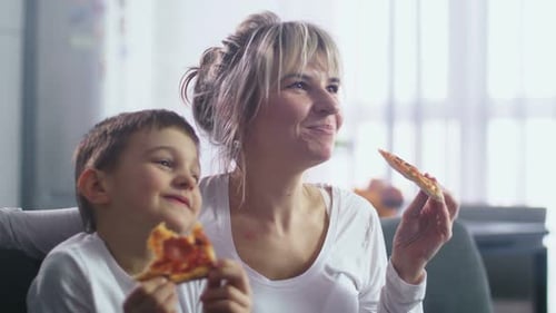 Mother and Son Enjoying Pizza Together Indoors